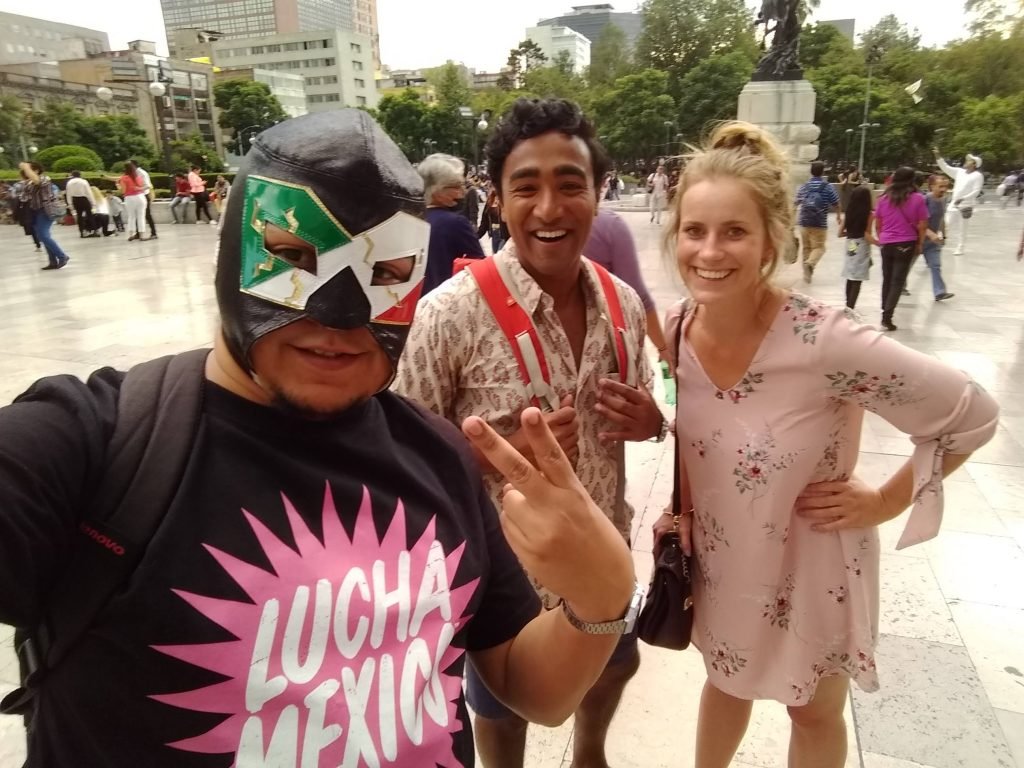 Alexis Sánchez and two more smiling persons attending a Lucha Mexico Experience tour in Palacio de Bellas Artes